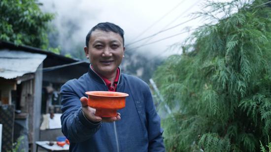  扎西巴珠展示他制作的木碗。新華網(wǎng) 旦增努布攝